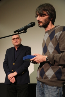 Šéfredaktor Film.sk Daniel Bernát preberá ocenenie.